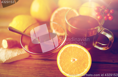 Image of tea with honey, orange and rowanberry on wood