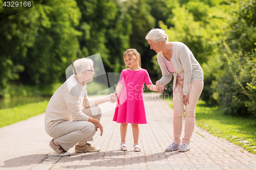 Image of senior grandparents and granddaughter at park