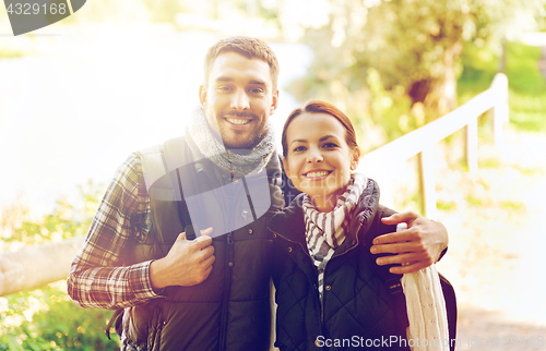 Image of happy couple with backpacks hiking and hugging