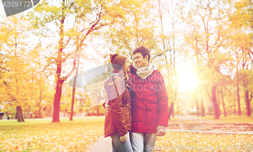 Image of happy young couple walking in autumn park