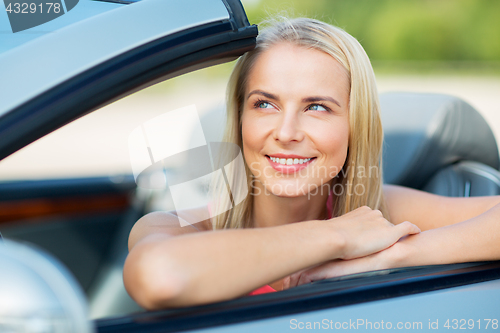 Image of happy young woman in convertible car