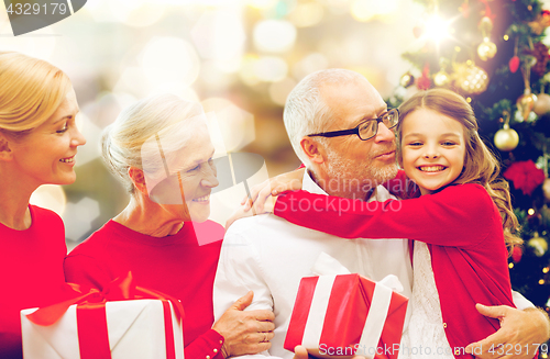 Image of happy family with christmas gifts over lights