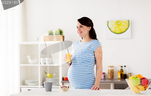 Image of happy pregnant woman having breakfast at home