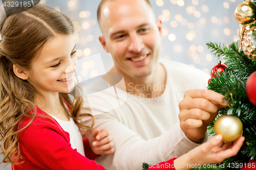Image of father and daughter decorating christmas tree