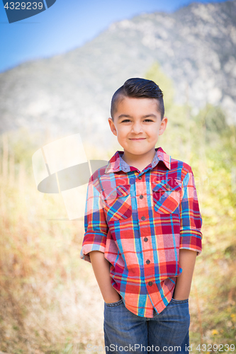 Image of Mixed Race Young Boy Standing Outdoors.