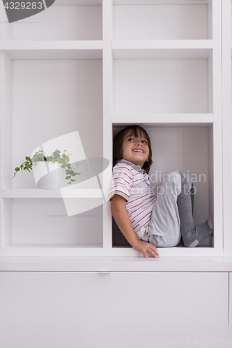 Image of young boy posing on a shelf