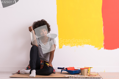 Image of back female painter sitting on floor