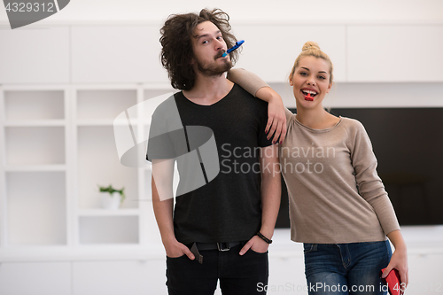 Image of couple in party hats blowing in whistle