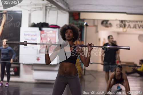 Image of black woman lifting empty bar