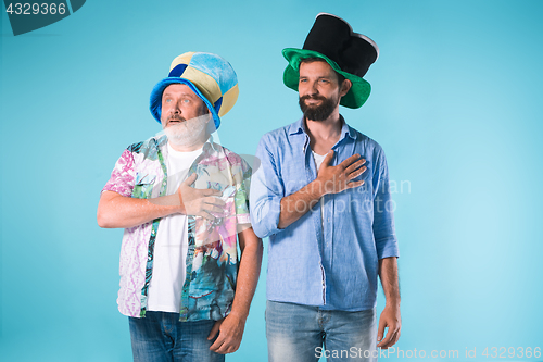 Image of The two football fans singing the national anthem over blue