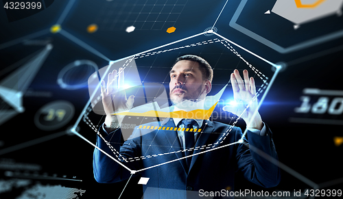 Image of businessman working with charts on virtual screen