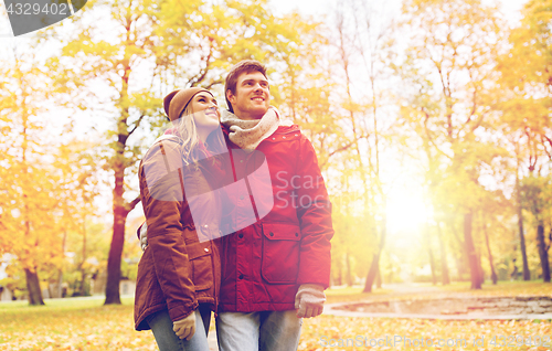 Image of happy young couple walking in autumn park