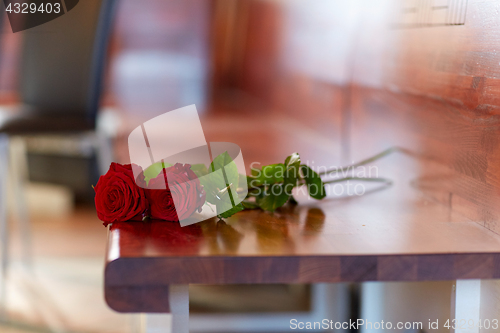 Image of red roses on bench at funeral in church