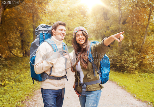 Image of smiling couple with backpacks hiking