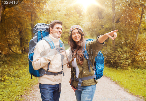 Image of smiling couple with backpacks hiking