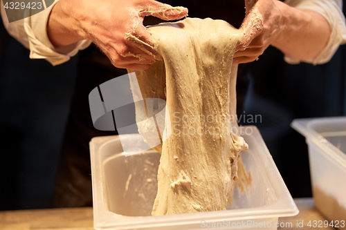 Image of close up of baker hands making bread dough