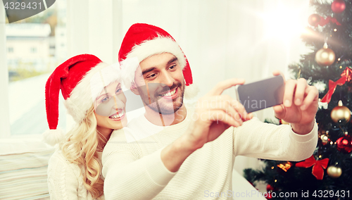 Image of couple taking selfie with smartphone at christmas