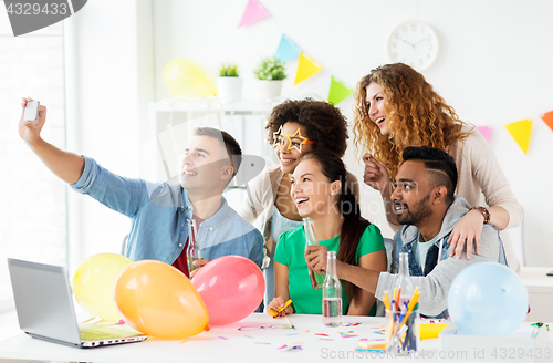 Image of happy team taking selfie at office party