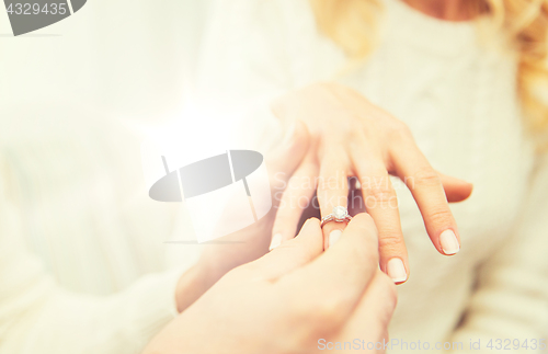 Image of close up of man giving diamond ring to woman