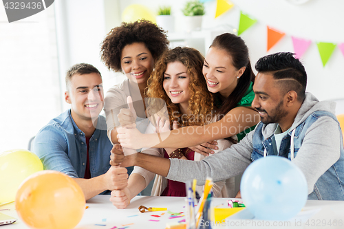 Image of happy team at office party showing thumbs up