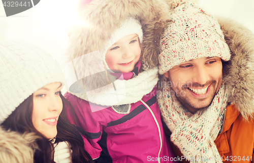 Image of happy family with child in winter clothes outdoors