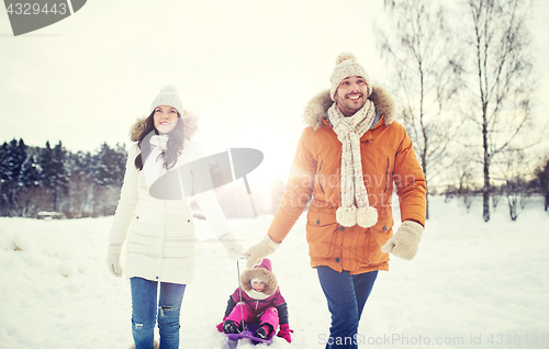 Image of happy family with sled walking in winter outdoors