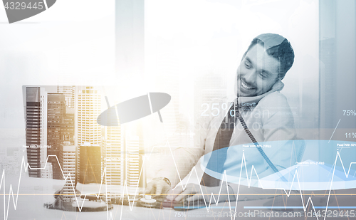 Image of businessman with computer calling phone at office