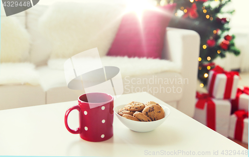 Image of close up of christmas cookies and red cup on table