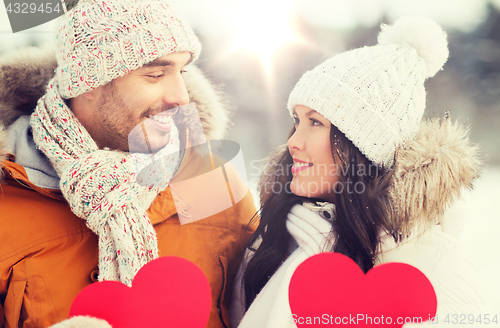 Image of happy couple with red hearts over winter landscape