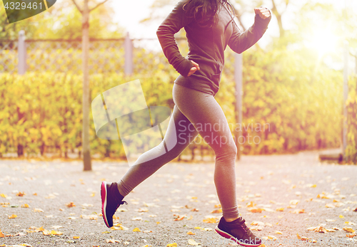 Image of close up of young woman running in autumn park