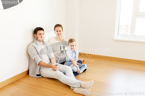 Image of family taking selfie by smartphone at new home