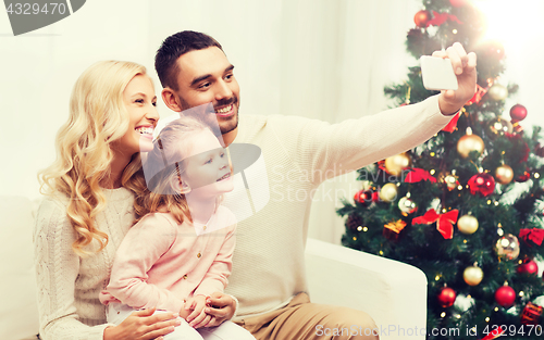 Image of family taking selfie with smartphone at christmas