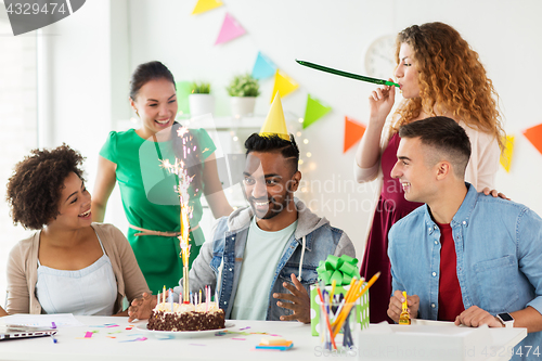 Image of team greeting colleague at office birthday party