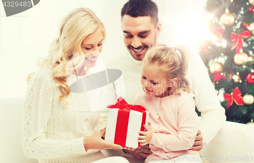 Image of happy family at home with christmas gift box