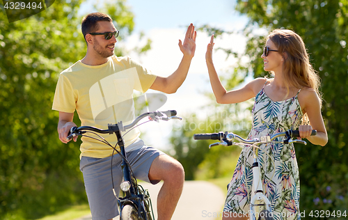 Image of happy couple with bicycles making high five