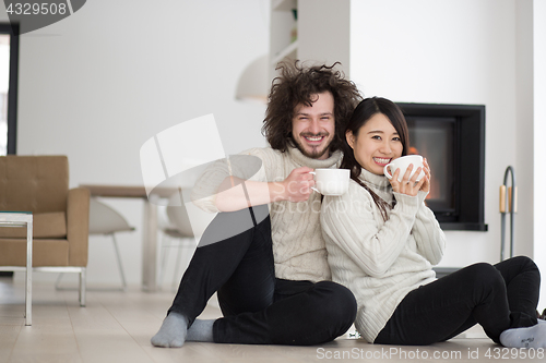 Image of happy multiethnic couple  in front of fireplace