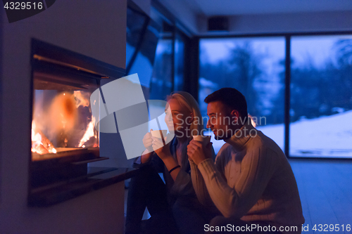 Image of happy couple in front of fireplace