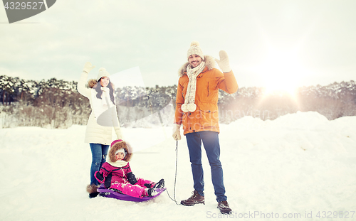 Image of happy family with sled walking in winter outdoors