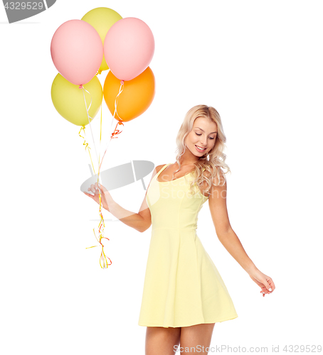 Image of happy woman in dress with helium air balloons