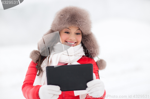 Image of woman in winter fur hat with tablet pc outdoors