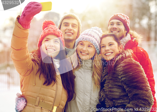 Image of happy friends taking selfie with smartphone