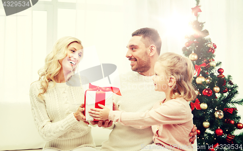 Image of happy family at home with christmas gift box