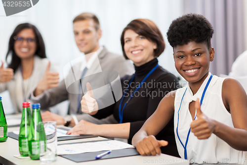 Image of people at business conference showing thumbs up