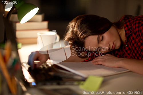 Image of student or woman sleeping on table at night home