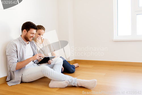 Image of happy couple with tablet pc computer at new home