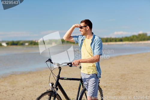 Image of happy man with bicycle on summer beach