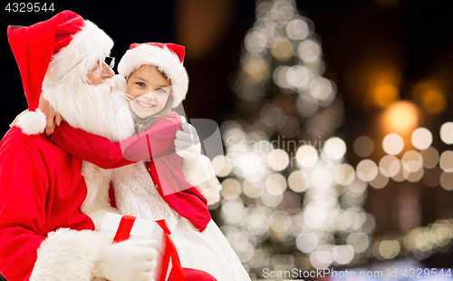 Image of santa claus with happy girl over christmas tree