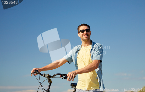 Image of happy smiling man with bicycle outdoors