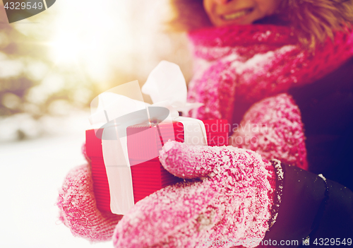 Image of close up of woman with christmas gift outdoors