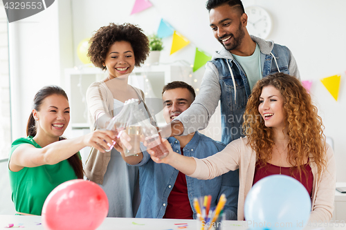 Image of happy team with drinks celebrating at office party